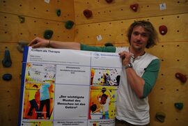 Bildzeile: Peter Lorenz präsentiert sein Poster vor der klinikeigenen Kletterwand. (Foto: Böttner)