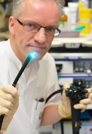 PD Dr. Carsten Schmidt zeigt ein spezielles Endoskop, das zur Magenspiegelung eingesetzt wird. Die blaue Farbe dient der besseren Erkennung und Interpretation von Schleimhautveränderungen. (Foto: UKJ / Szabó)