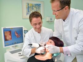 Dr. Oliver Schäfer und Privatdozent Dr. Arndt Güntsch von der Zahnklinik am UKJ fertigen einen digitalen Abdruck vom Gebiss der Patientin an. (Foto: UKJ / Szabo)