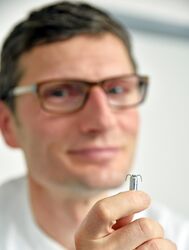 Privatdozent Dr. Dirk Prochnau zeigt den nur 18 Millimeter langen Schrittmacher. Foto: UKJ/Szabo.